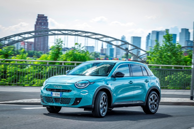 Der neue Fiat 600 Hybrid in Tuerkis-Metallic vor der Frankfurter Skyline