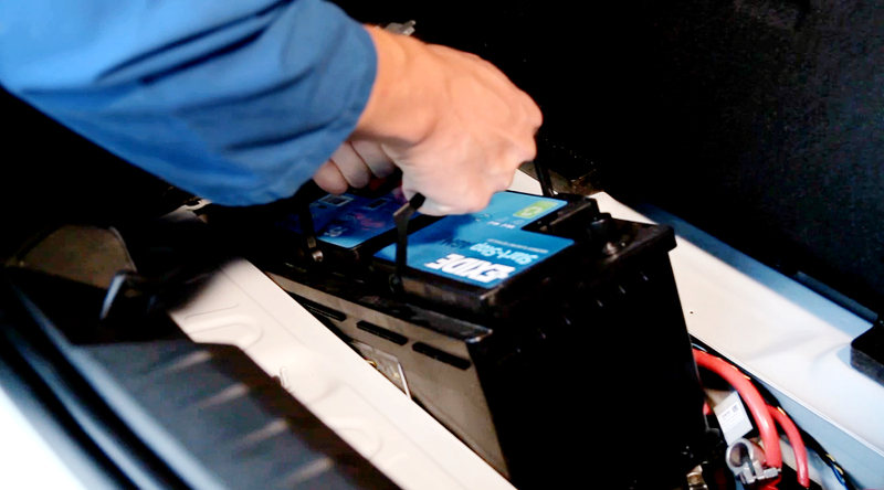 Auto-Batterie Kfz-Mechatroniker holt Auto-Batterie aus Auto heraus