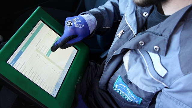 Kfz-Meister mit Diagnose-iPad beim Fahrzeugcheck 