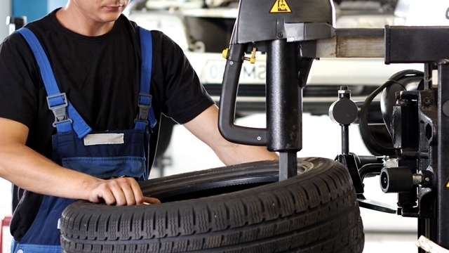 Reifenwechsel Werkstattmitarbeiter beim Reifenwechsel